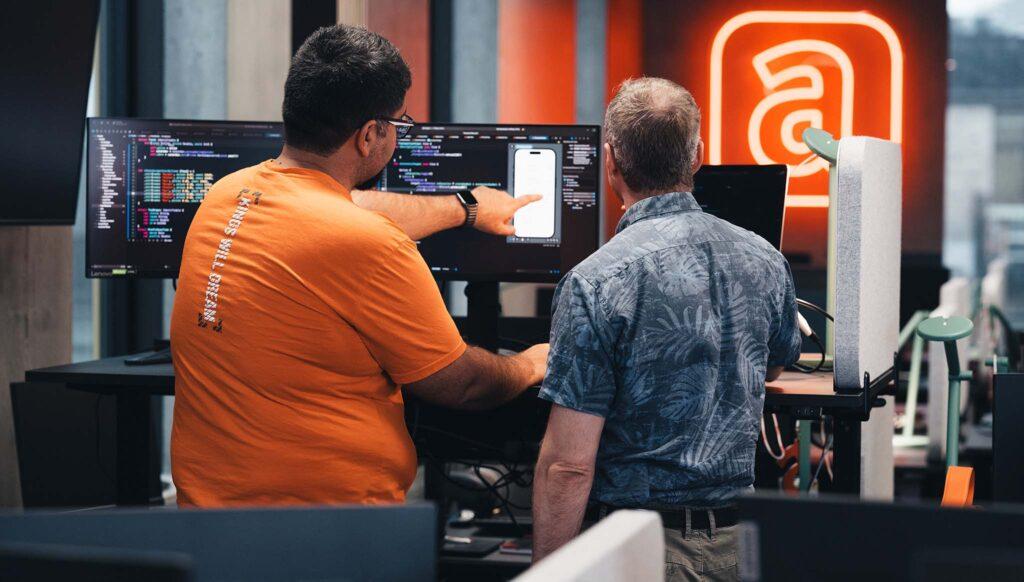 coworkers showing work on screen