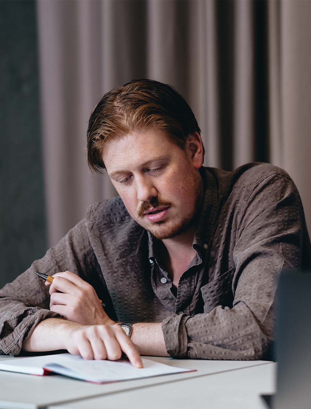 man pointing at his notes on desk