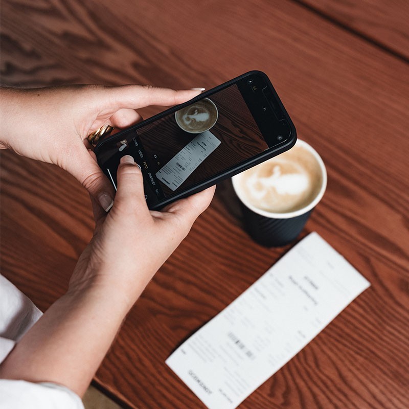 taking picture of receipt with coffee on table