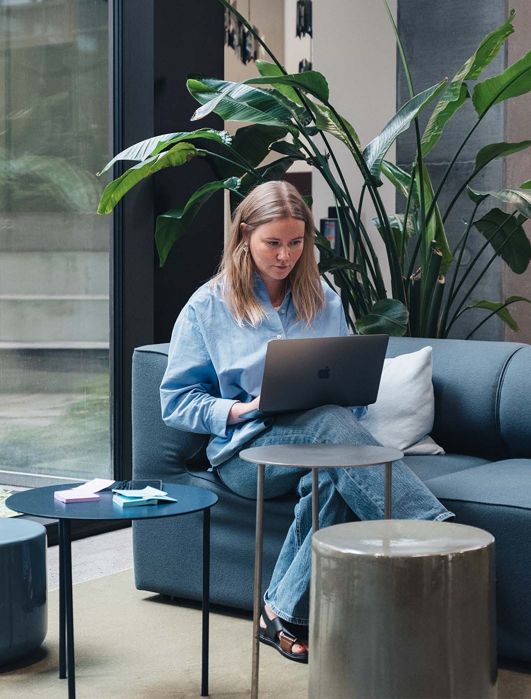 woman sitting with computer on sofa