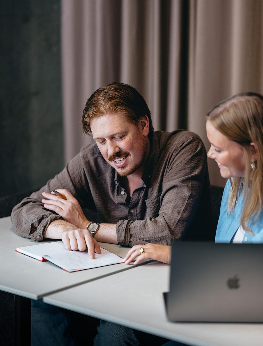 coworkers smilling with notebook